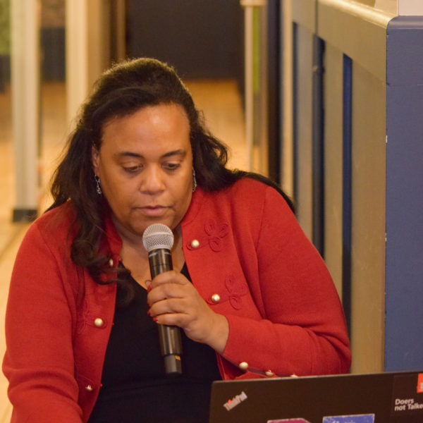 One presenter holding the microphone while on the computer