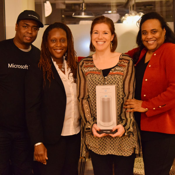 Four presenters smiling in a photo after gifting one of them with a portable speaker