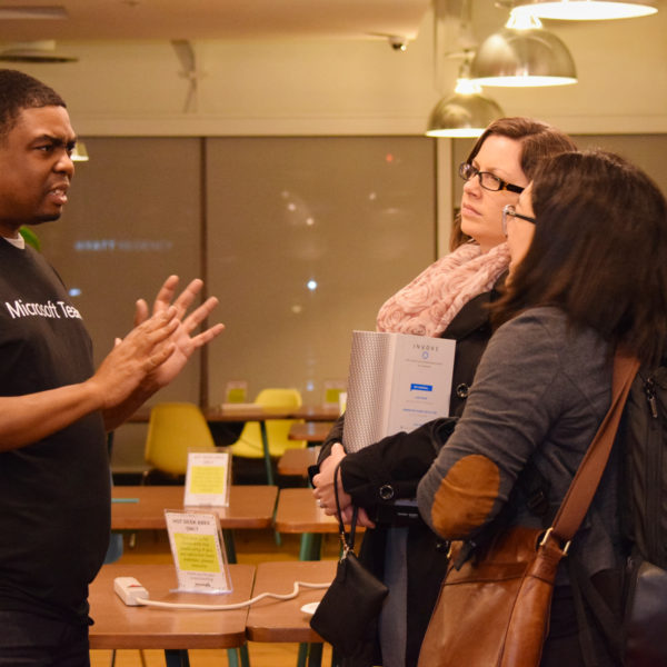 The presenter answering questions from two people after the presentation